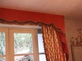 a window with a curtain and a mirror in the room
