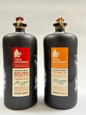 deux bouteilles de vin sont posées l'une à côté de l'autre sur une surface blanche
