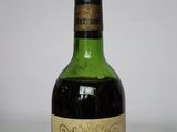 an old bottle of wine sitting on top of a table
