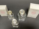 three bottles of perfume sitting on top of a table next to each other