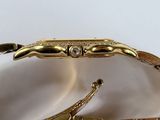 a close up of a gold bracelet with a diamond on it