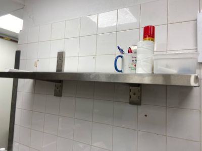a bathroom with a sink, mirror, and toiletries on the wall