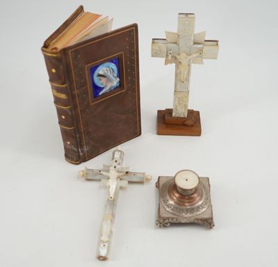 un livre, une croix et une bougie posés sur une table