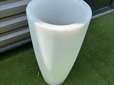 a white vase sitting on the grass next to a building