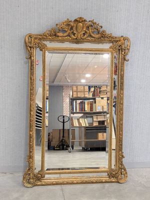 une image représentant un miroir à cadre doré posé par terre