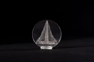 a close up of a clear glass object on a black surface