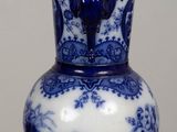 a blue and white vase sitting on a wooden table
