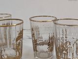 four glasses that are sitting on a marble table