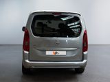 the back of a silver van is parked in a large room
