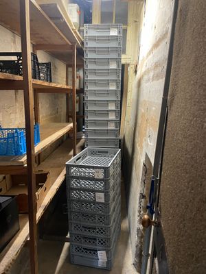 une pile de caisses dans une pièce étroite équipée d'étagères