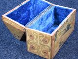 a wooden box that has a blue lining inside of it
