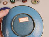 a person holding a blue plate with a chinese writing on it
