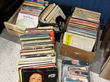 a lot of records in a box on the floor