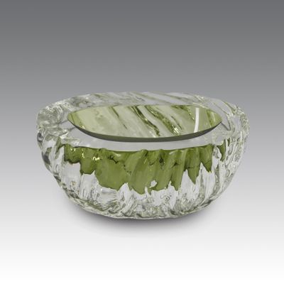 green and white glass bowl with a silver rim on a gray background