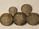 six different types of coins sitting on top of a white surface
