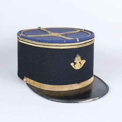 casquette bleu marine avec une bordure dorée et un poisson sur le devant