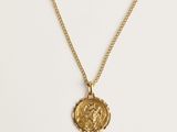 un collier en or avec une pièce de monnaie sur une chaîne