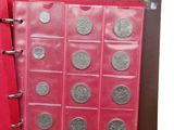 a red book with a bunch of coins inside of it