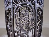a silver vase with intricate designs on it sitting on a table