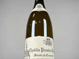 an old bottle of wine sitting on top of a white table
