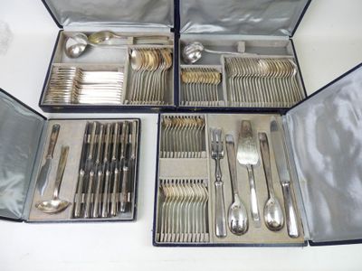 des couverts dans un coffret en argent posé sur une table blanche