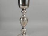 a close up of a silver cup on a white surface