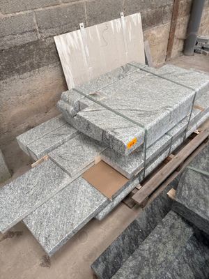many pieces of granite sitting on a pallet in a warehouse