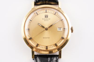 une montre en or avec un bracelet noir sur un fond blanc