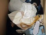 a cardboard box filled with clothes and a pair of shoes