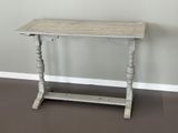 une petite table avec un plateau en bois posée sur un sol marron