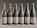 six bottles of wine are lined up in a row on a table