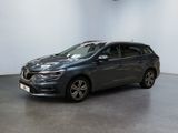 a grey car is parked in a room with a white wall