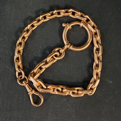 une chaîne en or posée sur un tissu noir