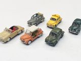 plusieurs petites voitures sont alignées sur une surface blanche