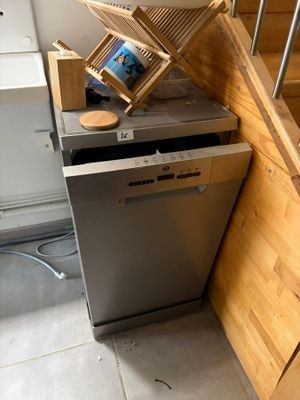 un lave-vaisselle dans un coin de la cuisine, près de l'escalier