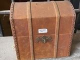 a small brown suitcase sitting on the ground