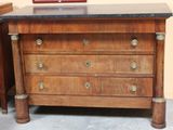 a wooden chest of drawers with a marble top
