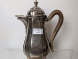 a silver coffee pot sitting on a glass shelf