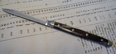 un couteau posé sur une feuille de papier