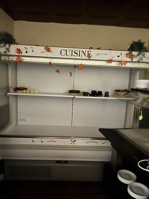 une cuisine équipée d'un réfrigérateur et d'un plan de travail sur lequel sont posés de la vaisselle