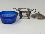 two blue glass bowls and a silver plate on a white surface