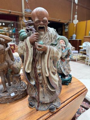 statue of a man with a goat and a goat on a table in a store