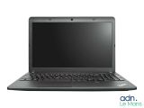 un ordinateur portable à l'écran noir posé sur une surface blanche