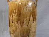 a brown vase with handles on a white table