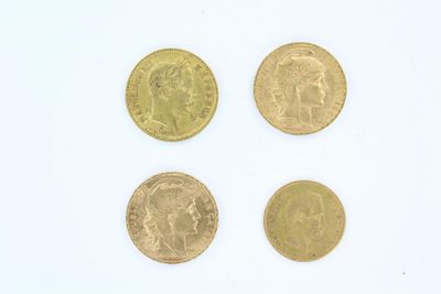 quatre types différents de pièces d'or sur une surface blanche