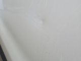 a close up of a white sink with a black handle