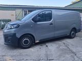 a grey van parked in a parking lot next to a building