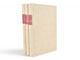 trois livres sont empilés sur une surface blanche
