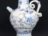 a blue and white vase with a handle on a black background