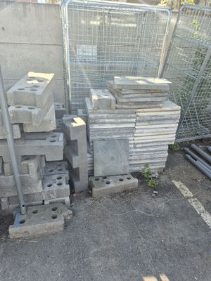 a pile of concrete blocks on the ground next to a fence